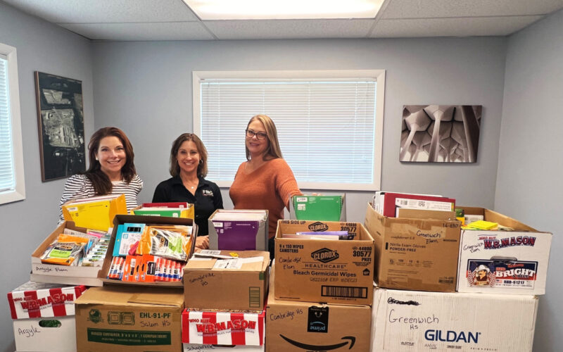Associates with boxes of school supplies.